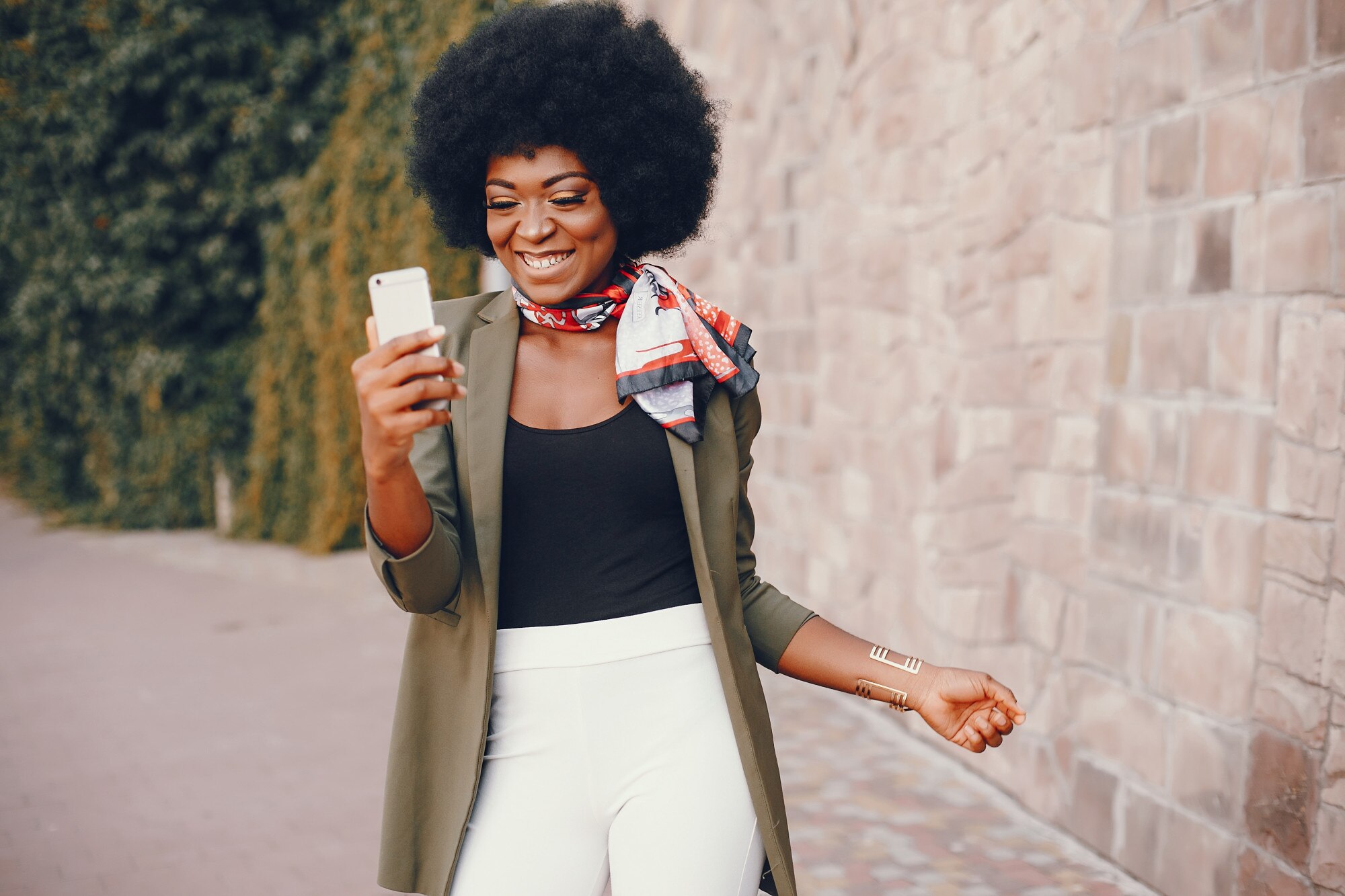 Jeune femme souriante qui regarde son téléphone en ville